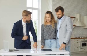 A young couple looks over paperwork in their living room, weighing housing options together.