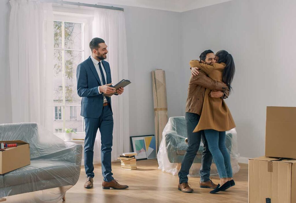 Buyer and real estate agent reviewing home documents at a kitchen table.